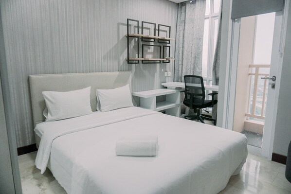 Une chambre d’hôtel avec un lit, un bureau et une chaise.