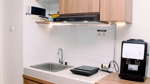 Een moderne keuken met een roestvrijstalen spoelbak, een inbouwoven en een koffieapparaat.