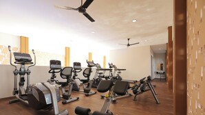 A gym with various exercise equipment, including treadmills, stationary bikes, and weight machines. - Comfort 2Br At Asatti Apartment (Pagedangan)