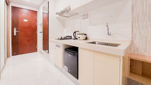 A modern kitchen with a sink, stove, and dishwasher. - Best Deal And Simply Look Studio Room At Sky House Bsd Apartment (Pagedangan)