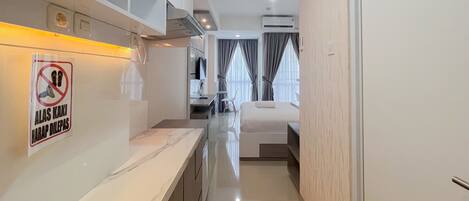 Ein modernes Hotelzimmer mit Küchenzeile, einem Bett und einem Badezimmer.