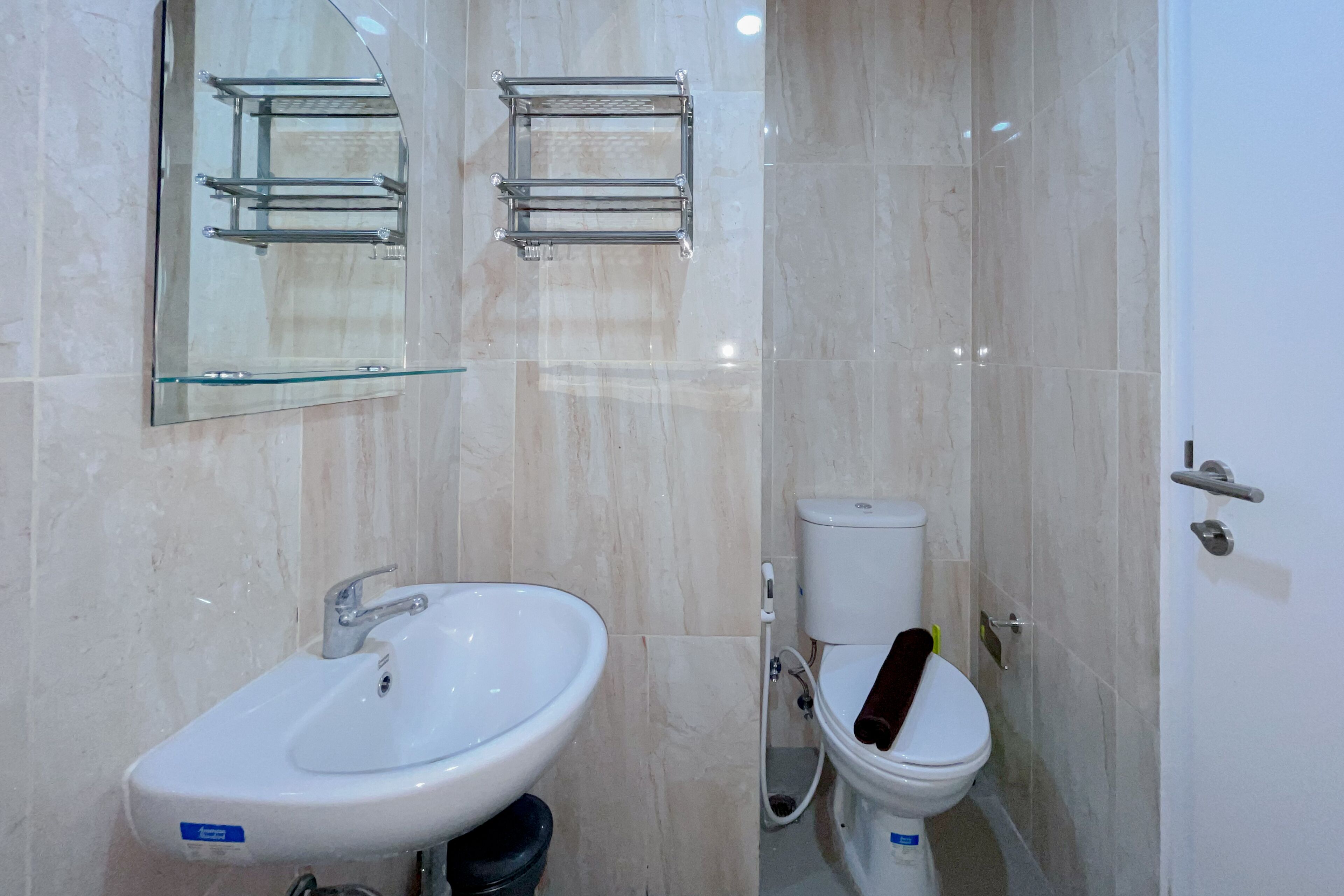 A bathroom with a white sink, a mirror, a toilet, and a glass shower enclosure.