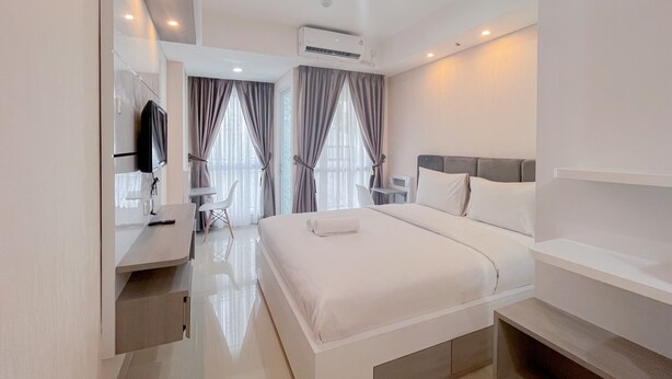 Une chambre d’hôtel moderne dot ée d’un grand lit, d’un bureau avec une chaise, d’une télévision à écran plat et d’un système de climatisation.