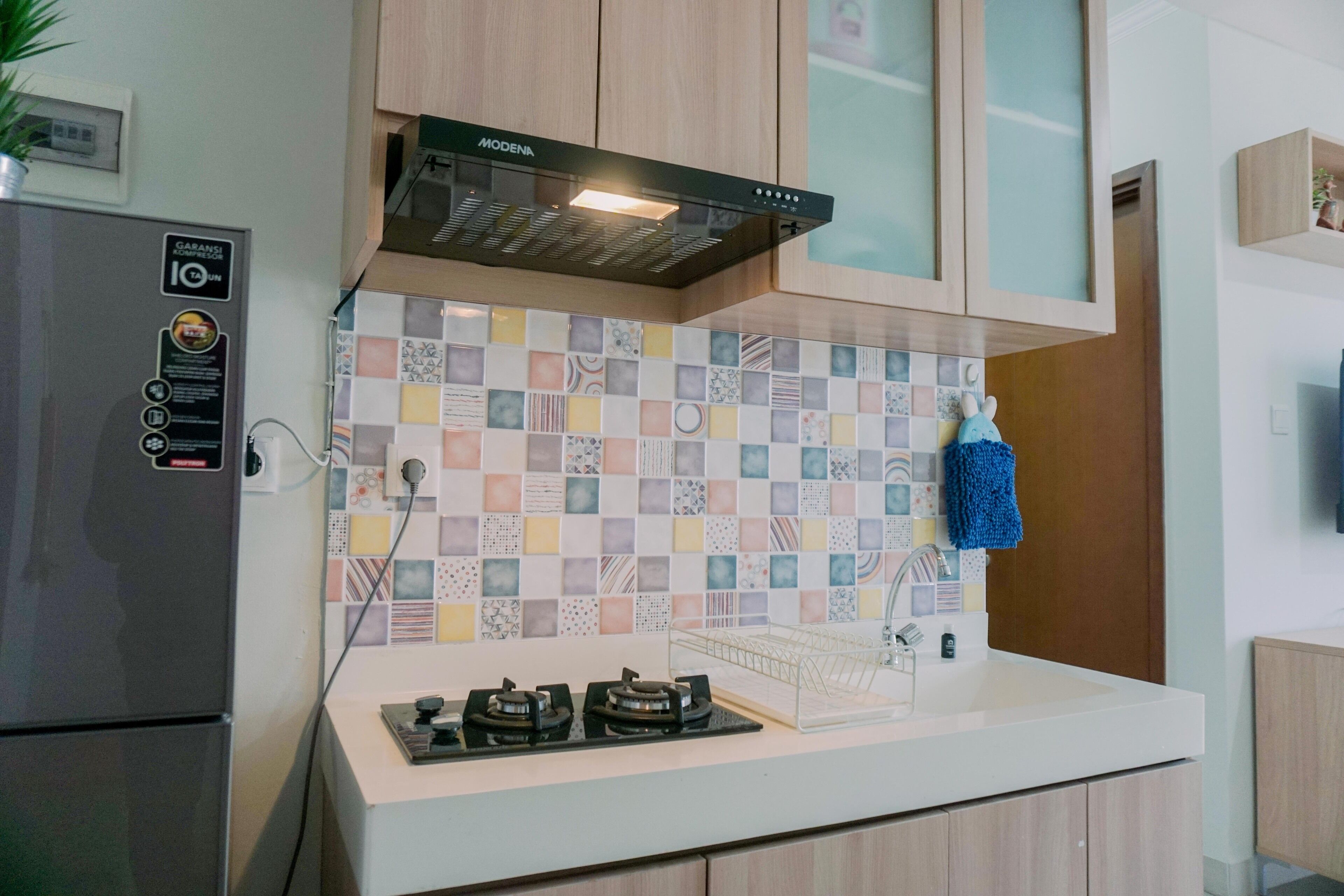Una cocina con estufa moderna, horno empotrado y extractor Modena.