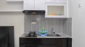 Una cocina con estufa a gas, un lavamanos y un escurreplatos azul.