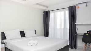Una habitación de hotel con una cama, un escritorio y una silla.