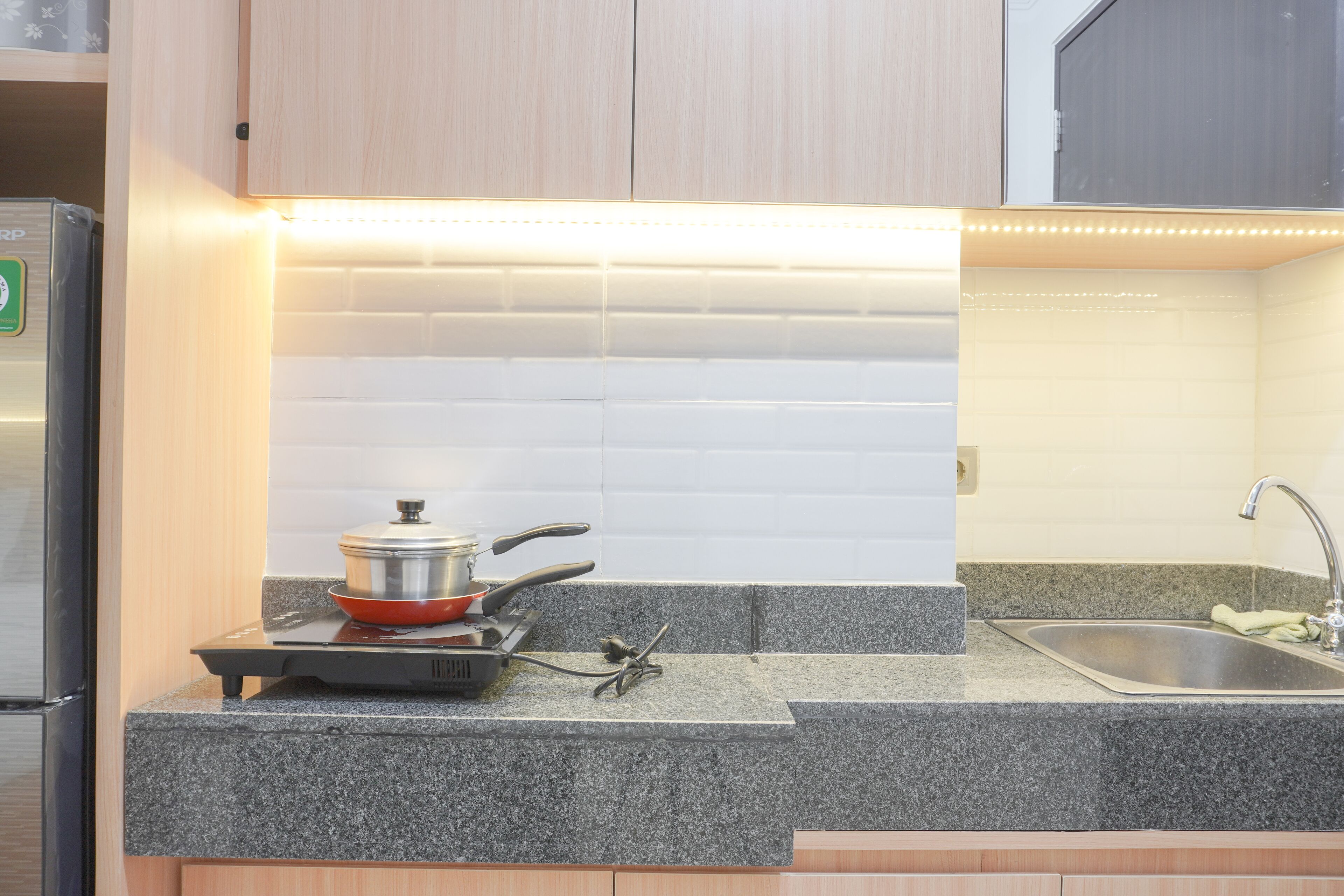 A kitchen with granite countertops, a stove, a sink, and wooden cabinets.