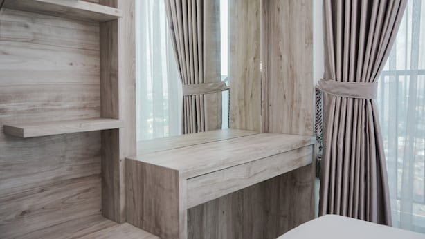 A modern bathroom with a wooden vanity, a mirror, and a window with curtains. - Minimalist And Nice Studio At Tree Park City Cikokol Apartment (Tangerang)