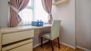 A room with a desk, a chair, a window with curtains, and a bag on the window sill. - Cozy Stay And Warm Studio Apartment At Margonda Residence 5 (Depok)