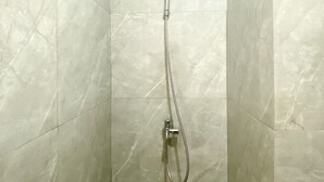A shower with a handheld showerhead and a flexible hose. - Comfort And Cozy Designed Studio Sayana Bekasi Apartment (Tarumajaya)