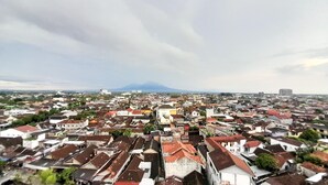 A cityscape with a mountain in the background. - Luxury Studio At Taman Melati Sinduadi Apartment (Pogung Lor)