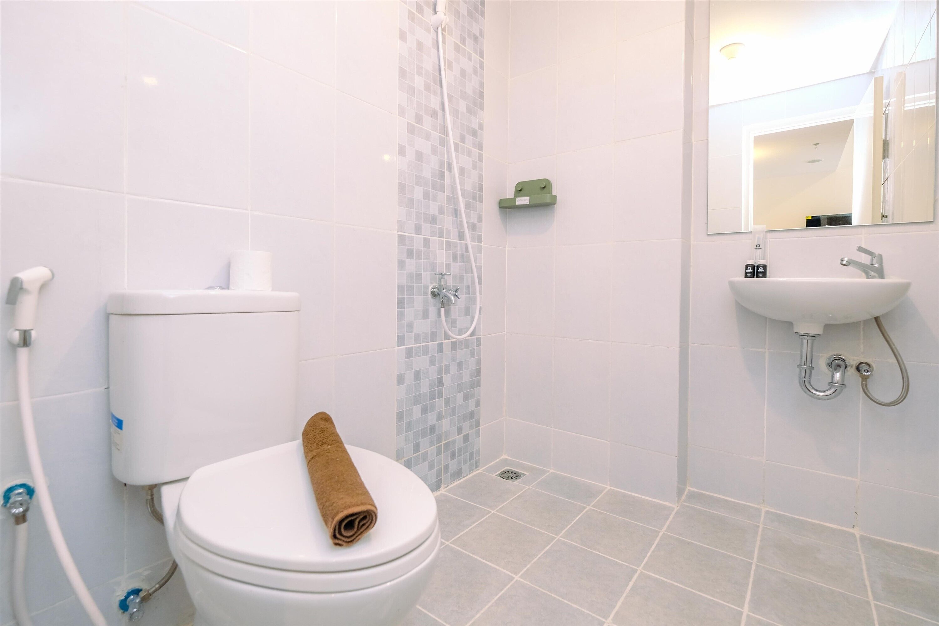 A bathroom with a toilet, a shower, and a sink.