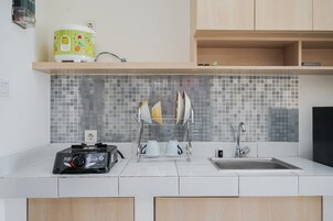 A modern kitchen with a gas stove, a sink, and a dish rack.