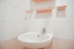 A bathroom with a white sink, a mirror, and a towel rack. - Best Homey 2Br Apartment Mediterania Palace Residence (Jakarta)