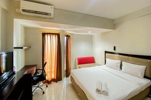 Relax in a spacious room with a large bed, desk, and air conditioning unit.