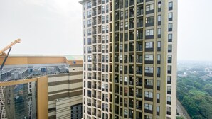 Un edificio de gran altura con varios balcones y una grúa de construcción al fondo.