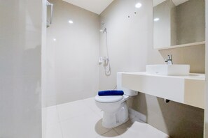 A modern bathroom with a white toilet, a shower, and a sink. - Warm And Enjoy Living 1Br Tree Park City Bsd Apartment (South Tangerang)