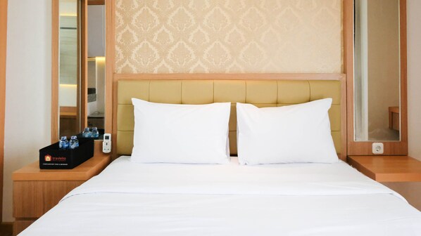 Guests can enjoy a comfortable night's sleep in this well-appointed room featuring a neatly made bed with two pillows and a clean duvet.