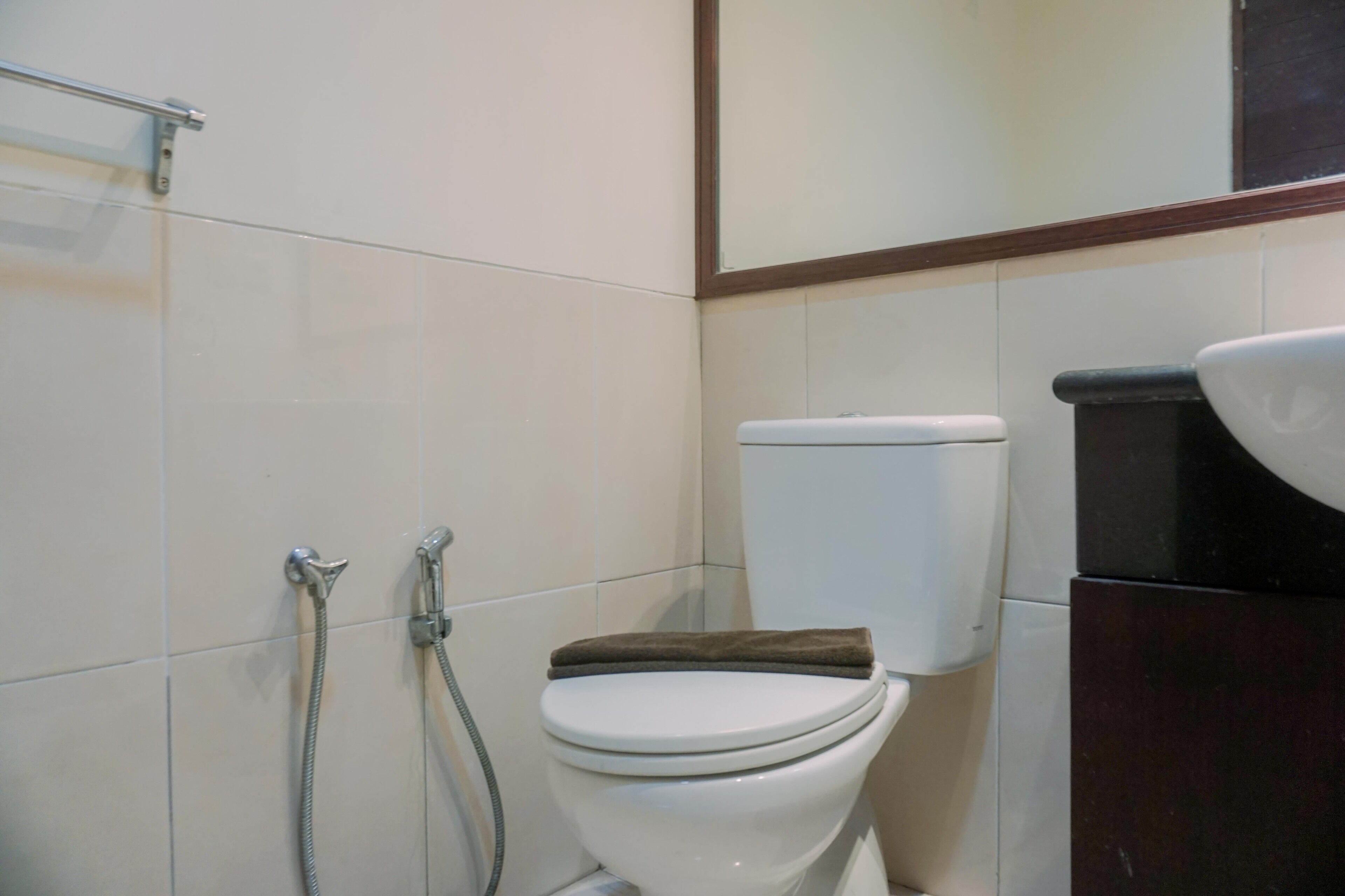 A bathroom with a toilet, a shower, and a sink.
