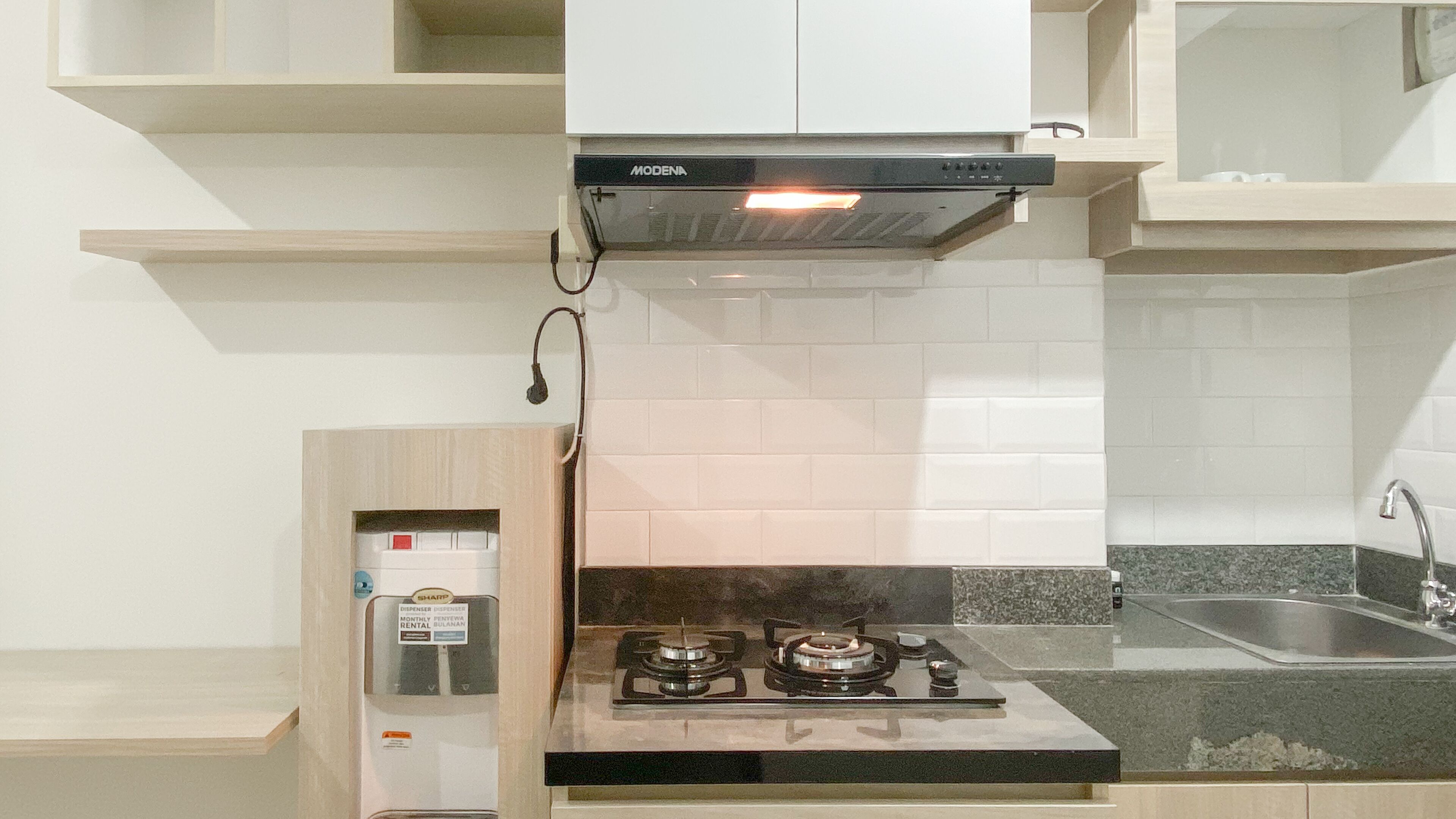 A compact kitchen with a gas stove, a built-in oven, and a modern faucet.