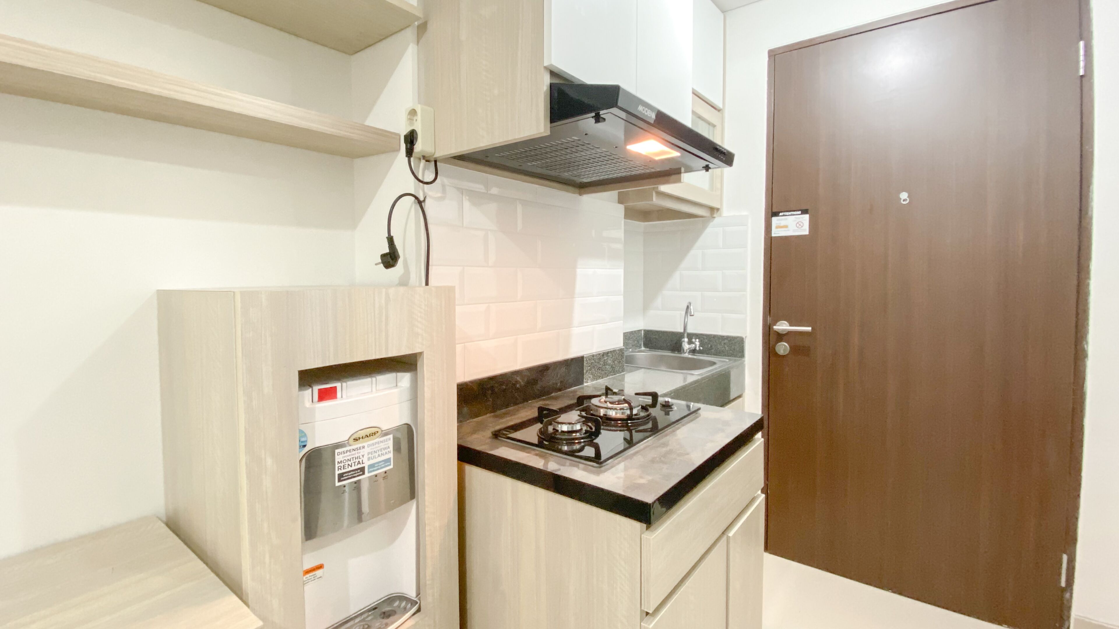A compact kitchen with a gas stove, a built-in sink, and a wooden cabinet.