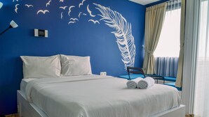 A bedroom with a bed, pillows, a wall-mounted thermostat, a ceiling fan, and a window with curtains. - Nice And Cozy Studio At Paddington Heights Apartment (Tangerang)