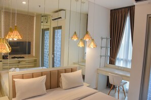 Relax in comfort with a neatly made bed, flat-screen TV, and spacious desk area.