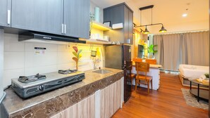 Une cuisine moderne avec des armoires grises, un plan de travail en marbre et une cuisinière à gaz intégrée.