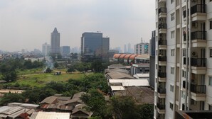 Un immeuble de grande hauteur doté de nombreux balcons et de plusieurs unités de climatisation.