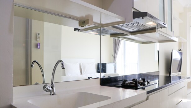 Une cuisine moderne avec un évier blanc, un robinet en acier inoxydable et un plan de travail noir.