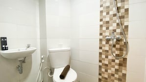 A bathroom with a toilet, sink, and shower. - Cozy Stay And Tidy 1Br The Alton Apartment (Semarang)