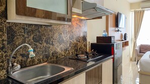 Een moderne keuken met een granieten aanrecht, een roestvrijstalen spoelbak en een inbouwfornuis.