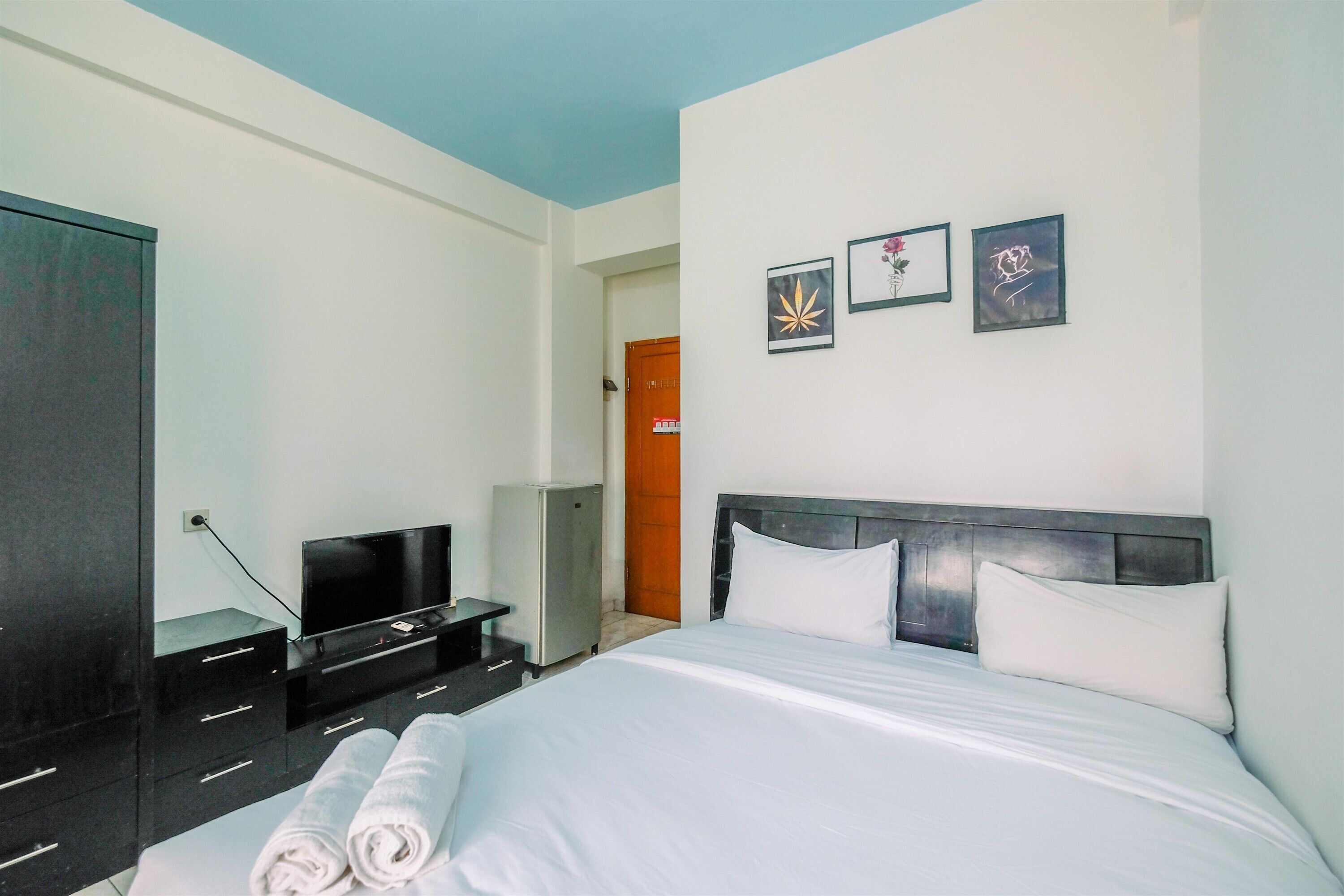 Una habitación de hotel con cama, televisión, escritorio y armario.