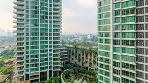 A high-rise building with multiple balconies and a courtyard with greenery. - Spacious 3Br At Kemang Village Apartment (Jakarta)