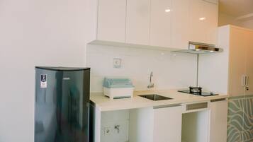 Estudio | Cocina privada | Frigorífico, placa de cocina, arrocera y mesa de comedor