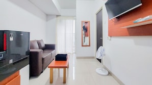 Una sala de estar moderna con un sofá, una mesita, un televisor montado en la pared y un ventilador.