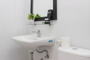 Bathroom features a pedestal sink, toilet, and mirror.