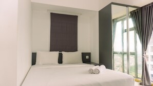 A hotel room with a large bed, a window with curtains, and a view of the outdoors. - Comfort 1Br At 32Th Floor Apartment M-Town Residence (Gading Serpong)