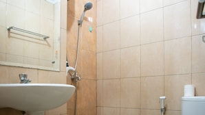 A bathroom with a sink, mirror, shower, and toilet. - Homey And Cozy Stay Studio At Margonda Residence 2 Apartment (Depok)