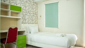A bedroom with a bed, a desk with drawers, a chair, and a window. - Homey And Cozy Stay Studio At Margonda Residence 2 Apartment (Depok)