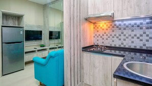 Una cocina moderna con horno empotrado, pileta de acero inoxidable y una silla azul.