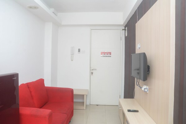 Cozy retreat with a sofa, table, and TV, featuring an entrance and easy access.