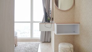 A modern bathroom with a large window, a vanity with a mirror, and a marble toilet. - Modern And Elegant 2Br At Menteng Park Apartment (Jakarta)