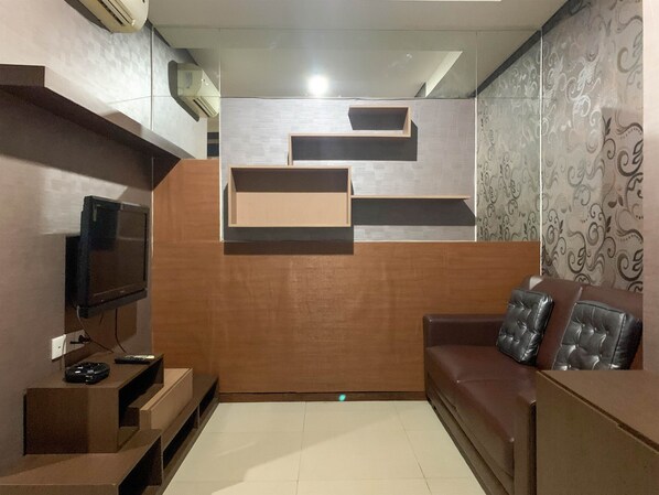 Relax in this stylish living room with a flat-screen TV, comfortable sofa, and wooden coffee table.