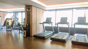 A gym with treadmills, weight machines, and a large window. - Comfortable 2Br At Apartment Casa Grande Residence (Jakarta)