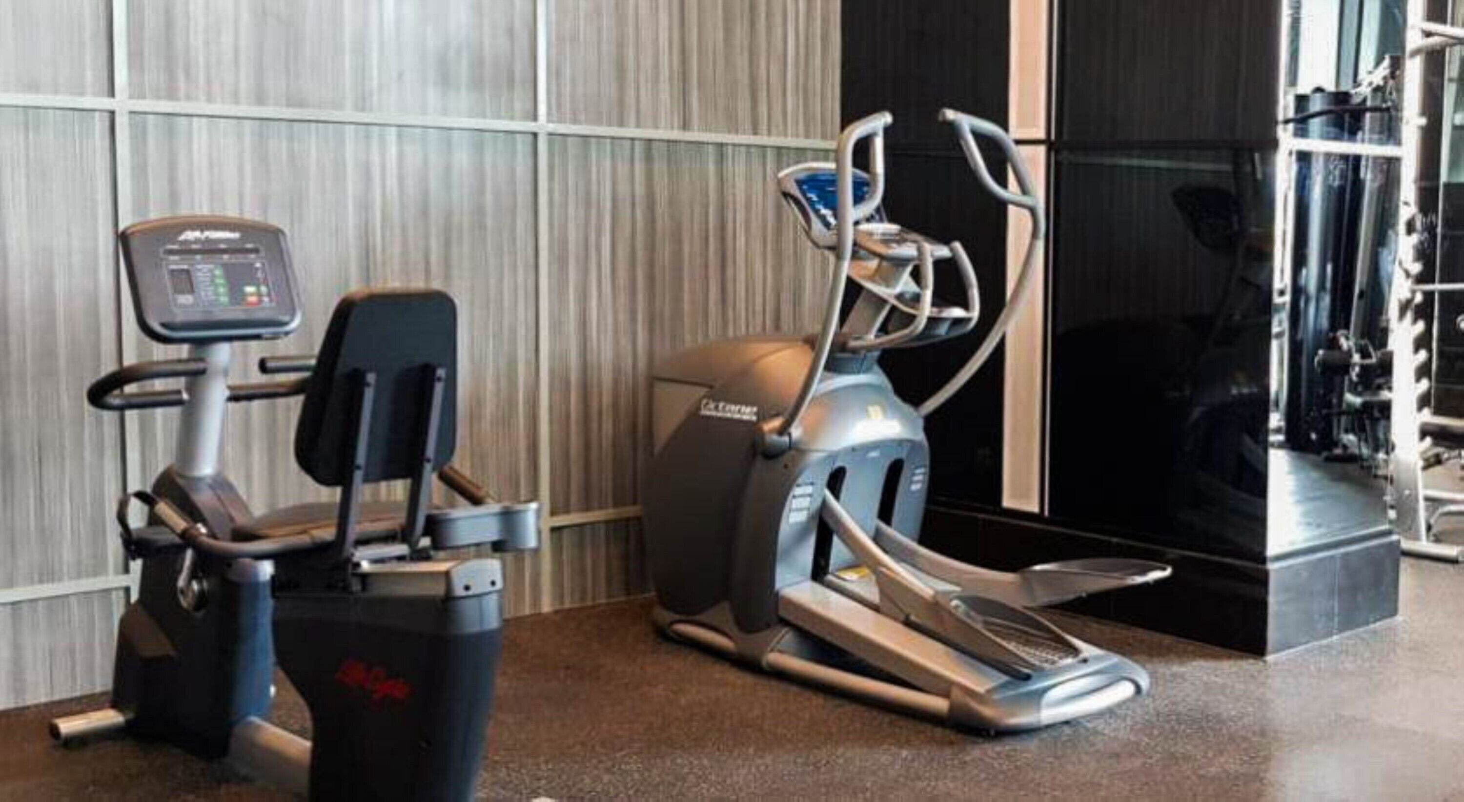 A gym with cardio machines, including a treadmill and an elliptical.