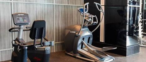 A gym with cardio machines, including a treadmill and an elliptical.