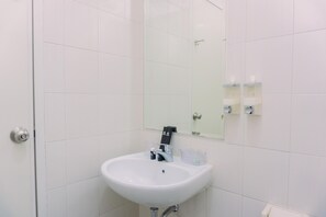 A white bathroom with a sink, mirror, and two soap dispensers on the wall. - Great Choice And Comfort 2Br At Signature Park Grande Apartment (Jakarta)