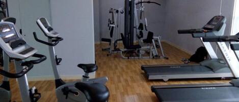 A gym with treadmills, elliptical machines, and weight equipment.