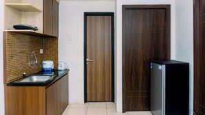 A compact kitchen with a sink, a kettle, and a refrigerator. - Cozy Stay 2Br Annora Living Apartment (Tangerang)